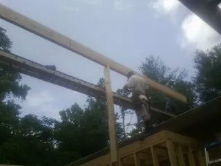 Carpenter setting a ridge beam over a new addition frame — Ice Dam Removal by Roofing Brothers in Jewett City