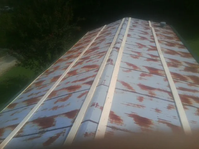 Rusted metal roof panels with new wood purlins before replacement — Storm Damage Roof Repair in Jewett City by Roofing Brothers