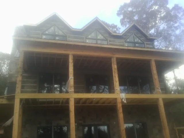 Dormers and porch framing on a large log home under construction — Roof Coating work by our crew in Jewett City