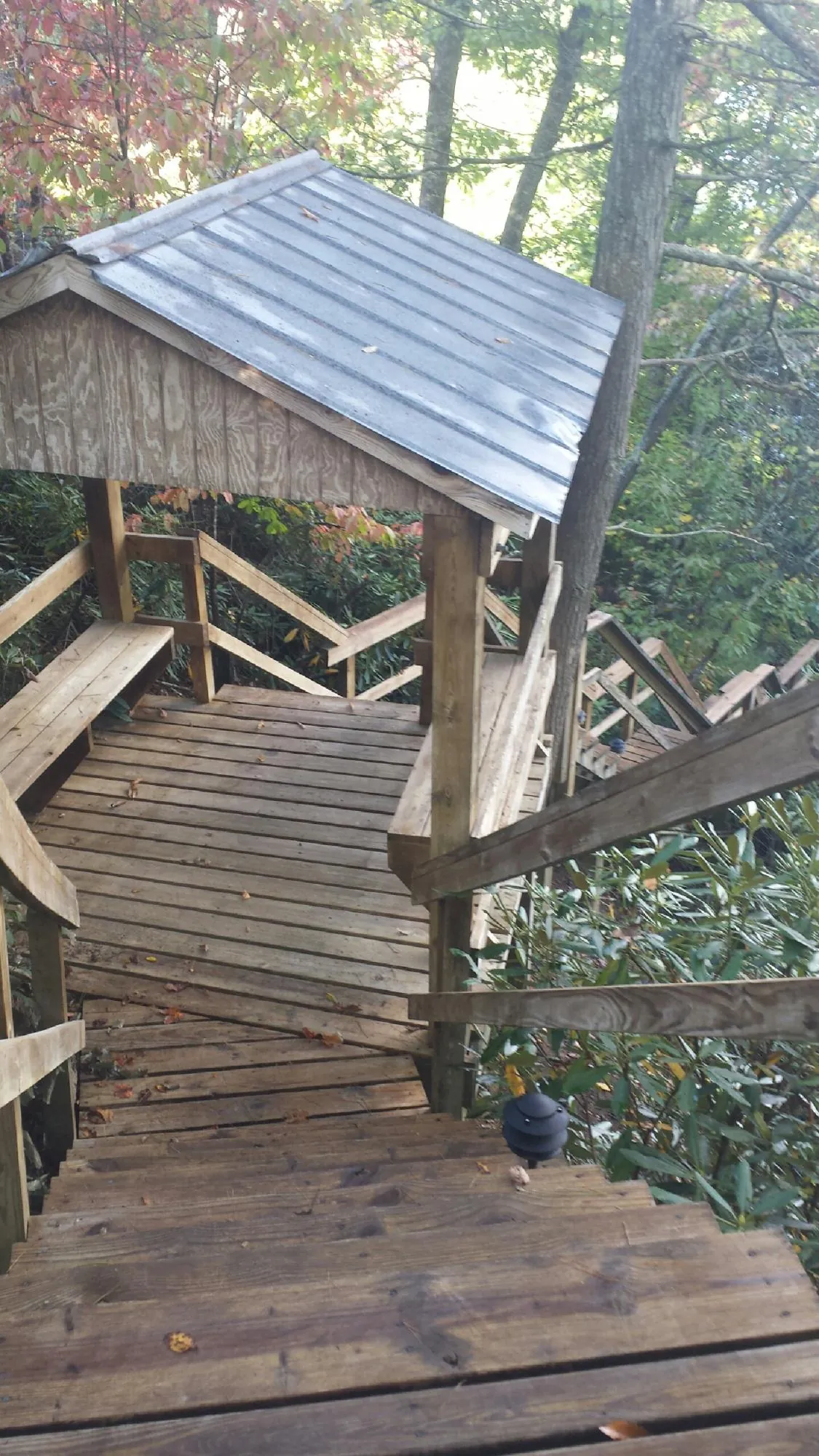 Metal roofed shelter over wooden steps on a wooded walkway — Skylight Repair & Installation work by our crew in Jewett City