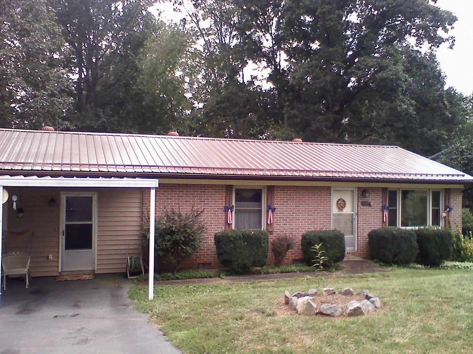 Bronze metal roof and carport on a brick ranch home — Roof Repair work by our crew in Jewett City